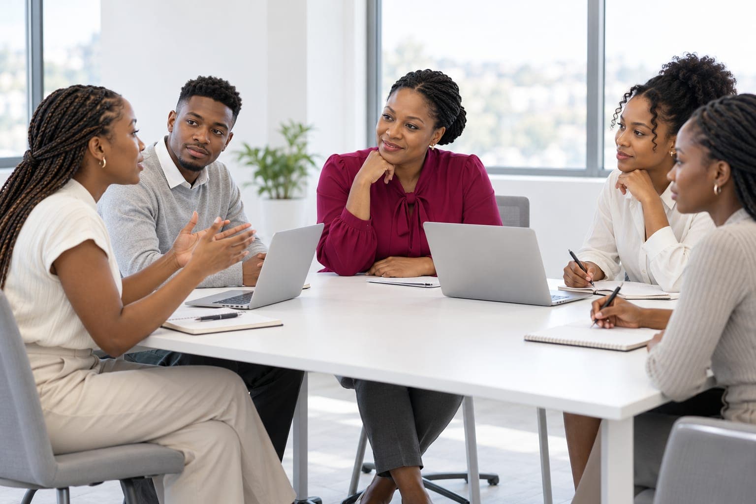 Facilitator leading a group discussion with young professionals around a meeting table